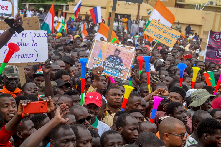 Thousands of anti-sanctions protesters holding Nigerien flags and Russian flags gather in support of the putschist soldiers in the capital Niamey, Niger on August 20, 2023. The sign reads 'all the people of Niger support 100% the CNSP'.