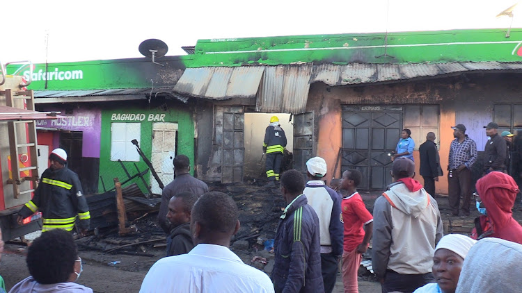 Business people and residents of Ichuga trading center at the Nyeri-Laikipia border at the scene where several business premises were gutted by fire on Wednesday dawn.