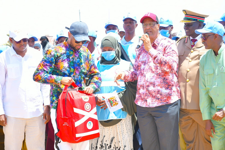 Garissa Health executive Ahmednadhir Omar (holding the the CHPs kit) and Governor Nathif Jama and during the launch of community health promoters in Bura town, Fafi subcounty, Garissa county.