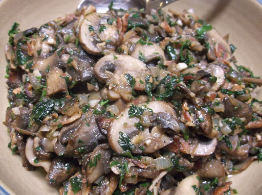 Sauteed mushrooms in bowl with spoon.