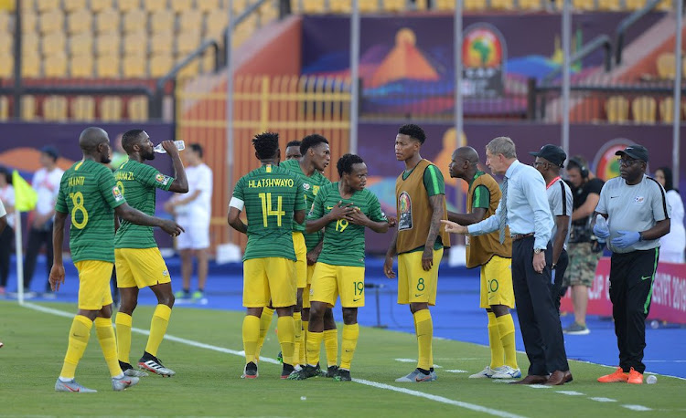 Bafana Bafana players take instructions from head coach Stuart Baxter during a water break against Ivory Coast.