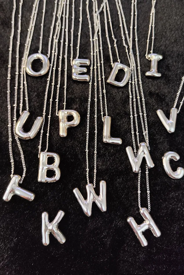 Glanzende zilveren koperen letter hanger, een stijlvol en gepersonaliseerd sieraad voor dames, perfect als cadeau.