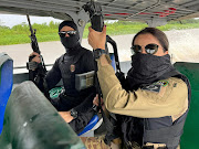 Federal Police officers hold weapons as they conduct a raid on a river during the Turquesa Operation, in Benjamin Constant Brazil November 30, 2023. 