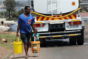 A man fetches water from a government-supplied water tank during one of the country's many water outages.