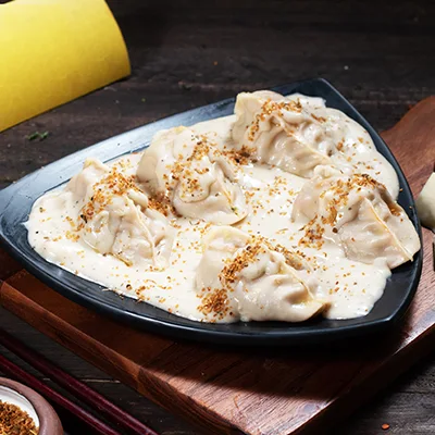 Chicken Momo In Molten Cheesy Sauce