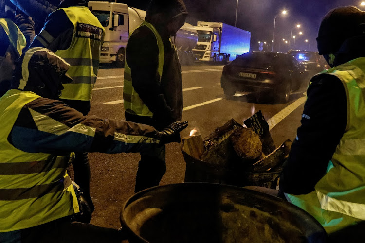 Polish truckers warm themselves by a fire during the Ukrainian border blockade near Hrebenne in Poland, November 19 2023. Picture: YAN DOBRONOSOV/REUTERS