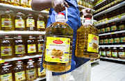 A person holds bottles of cooking oil made from oil palms at a supermarket in Subang Jaya, Malaysia, on March 8 2022. 