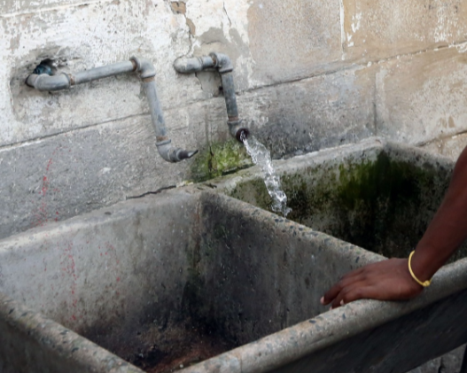 A broken tap with running water at Nancefield Hostel in Soweto.