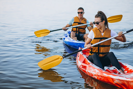 a man and a woman are paddling kayaks on a lake