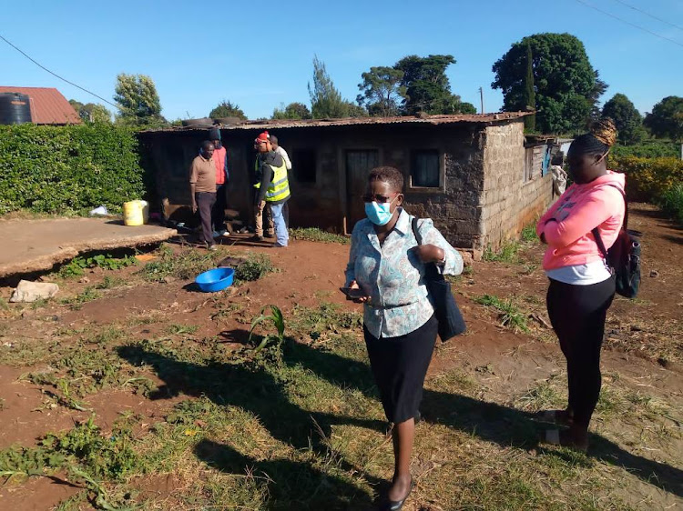 Kabuku chief Lucy Wanjiru leaves the home where three children perished in an inferno on Monday night.