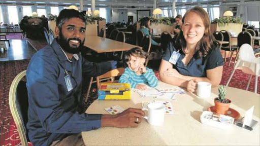 ALL ABOARD: Logos Hope director Seelan Govender, his wife Carlien and their son Milan enjoy a cup of coffee in the ship’s dining room where crew eat three meals a day. The Govenders say their children have spent more of their lives at sea than on land Pictures: BARBARA HOLLANDS