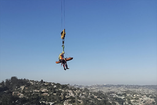 The accident victim is lowered to the ground using a construction crane at the Pavilion in Durban’s Westville.