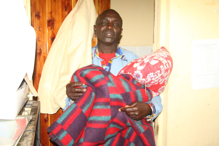 Baringo Ochii Special School Principal Stephen Ng’etich displays the bedding he spreads to sleep in his car and collects every morning to keep in his office.