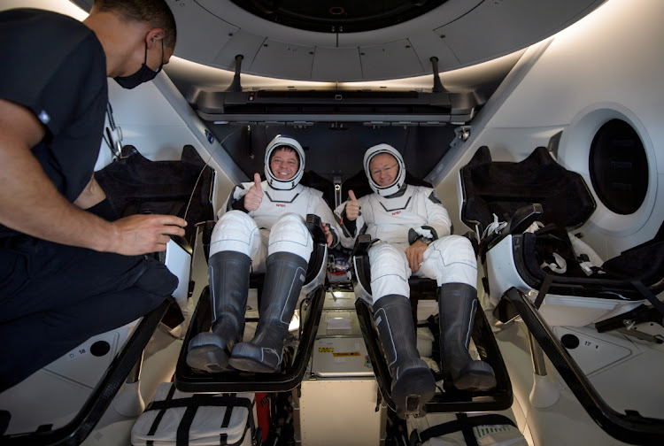 Nasa astronauts Robert Behnken, left, and Douglas Hurley inside the SpaceX Crew Dragon Endeavour spacecraft on board the SpaceX GO Navigator recovery ship shortly after having landed in the Gulf of Mexico off the coast of Pensacola, Florida, US, on Sunday