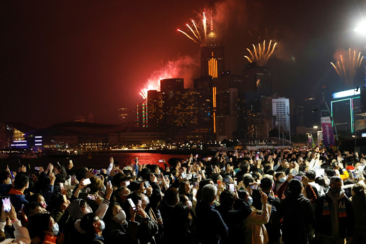 Fireworks explode over skyline building to celebrate New Year in Hong Kong, China on January 1 2022.