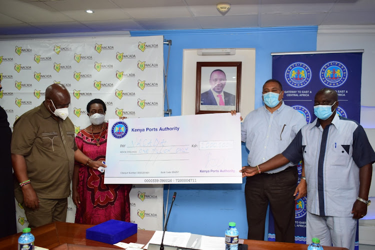 Nacada chief executive officer Victor Okioma and chairperson Prof Mabel Imbuga receive a Sh1 million cheque from Kenya Ports Authority managing director Rashid Salim