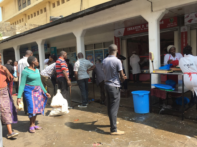 Traders and customers at City Market on Tuesday.