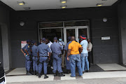 Police officers engage in discussions with members of the SA Chamber of Undertakers outside the department of home affairs head office in Pretoria.