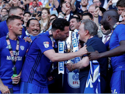 Cardiff City manager Neil Warnock, Gary Madine and team mates lift the trophy as they celebrate promotion to the premier league