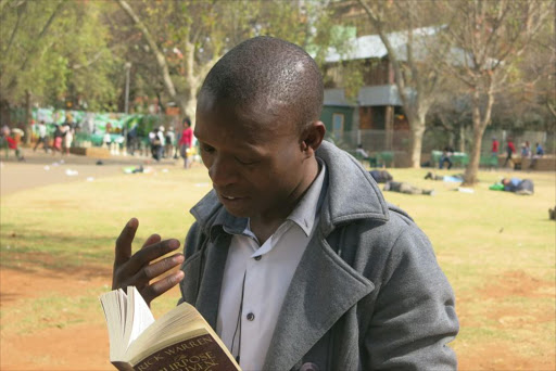 Philani Dladla is dubbed the Pavement Bookworm after seen reviewing books on Empire Road. Picture: Sowetan LIVE