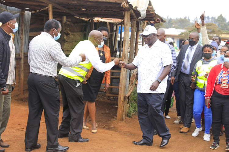 Kiambu Governor James Nyoro (white cap) greets residents of Gikambura on Tuesday.