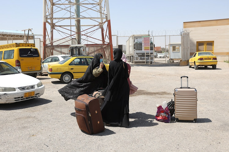 Afghan nationals stand at the Dowqarun border crossing between Iran and Afghanistan, Razavi Khorasan Province, Iran August 29, 2021.