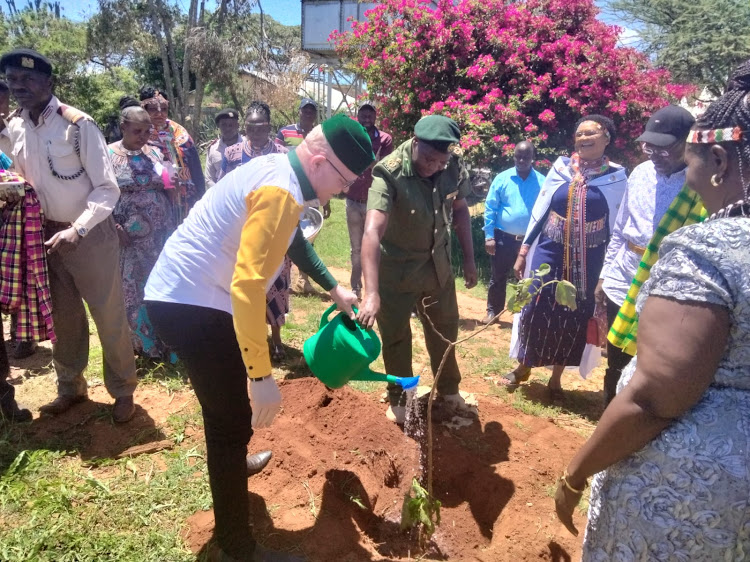 Webuye East MP Martin Pepela waters a tree at a past event.