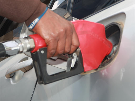 An attendant fuels a car at a petrol station on Koinange street. /FILE