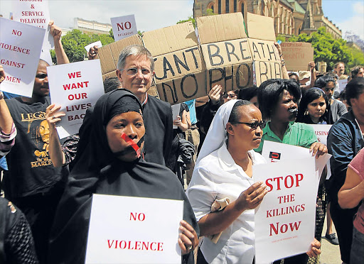 ENOUGH IS ENOUGH: The wives of foreign shopkeepers who were targeted by xenophobic looters in Grahamstown last week, are joined by concerned residents outside City Hall yesterday Picture: DAVID MACGREGOR