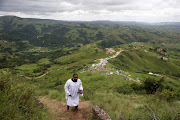 A member of Nazareth Baptist Church climbs a mountain to attend a church serive at Nhlangakazi mountain. Photo: SANDILE NDLOVU