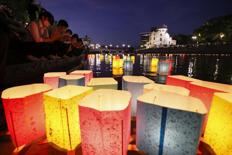 People release paper lanterns on the Motoyasu River facing the gutted Atomic Bomb Dome in remembrance of atomic bomb victims on the 77th anniversary of the bombing, in Hiroshima, Japan August 6, 2022, in this photo taken by Kyodo.