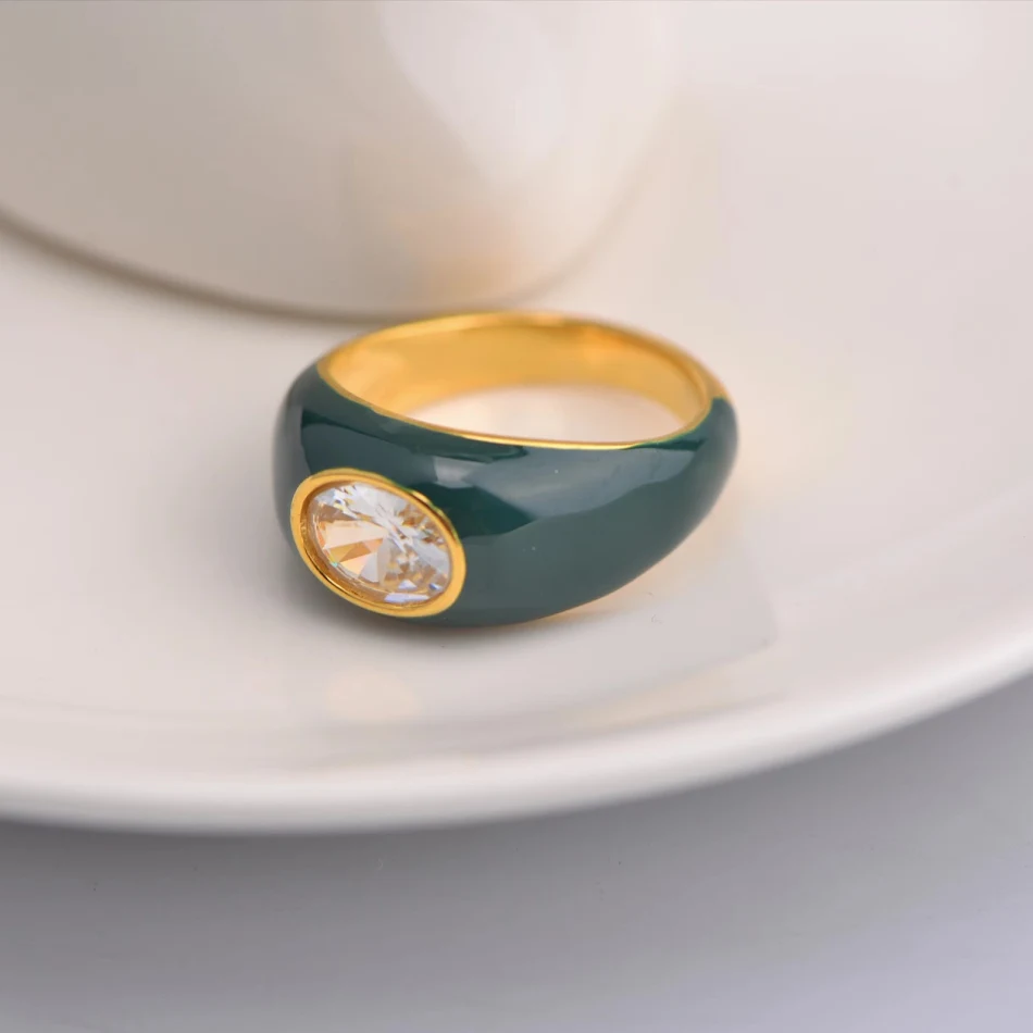 Anel quadrado cor café com diamante redondo verde, uma joia sofisticada para complementar seu visual com elegância e exclusividade.