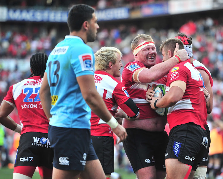 Malcolm Marx (R) of the Emirates Lions celebrates teammates after scoring a try during a Super Rugby semifinal match against the Waratahs at Ellis Park Stadium, Johannesburg on July 28 2018.
