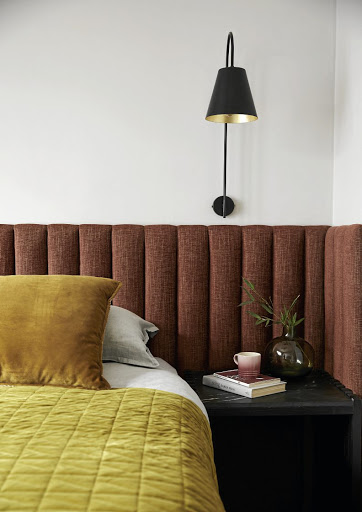 The upholstered headboard brings a sense of a tailored hotel experience to the main bedroom.