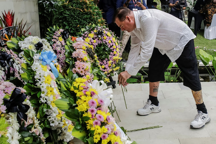 Australian Bali bombing survivor, Andrew Csabi lays a flower during the commemoration of the 20th anniversary of the Bali bombing that killed 202 people, mostly foreign tourists, including 88 Australians and seven Americans, at the Australian Consulate in Denpasar, Bali, Indonesia, October 12, 2022.