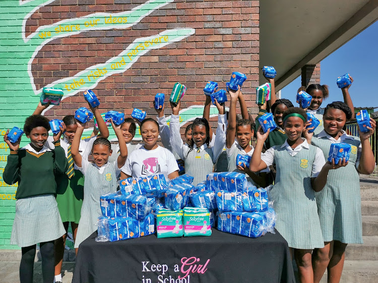 Keep a Girl in School founder Dinika Rooy, centre, hands over donations of sanitary pads to a group of Grade 7 girls from Aspiranza Primary School.