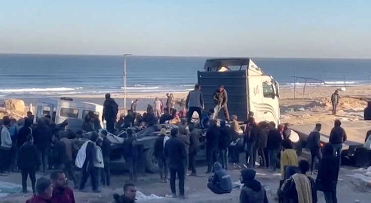 Palestinians transport casualties following what Palestinian health officials said was Israeli fire on people waiting for aid, in Gaza City, in this still picture taken from a video February 29 2024. Picture: REUTERS TV via REUTERS