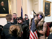 Jacob Anthony Chansley, also known as Jake Angeli, of Arizona, stands with other supporters of US President Donald Trump as they demonstrate on the second floor of the US Capitol building after breaching security defences, in Washington, US, on January 6 2021. 