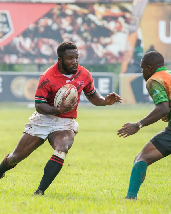 Kenya Simbas winger Joel Inzuga attempts to beat his Zambian opponent during their Victoria Cup match at Kyadondo Rugby Club in Kampala