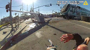 A screen grab from a police body camera video shows the pilot of a plane that crashed on railway tracks being rescued by Los Angeles Police Department officers moments before a train hit the aircraft in Los Angeles, California.