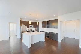 Large kitchen with an accent center island, clean white quartz countertops, and dark brown modern cabinets