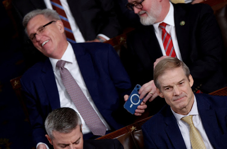 Former Speaker of the House Kevin McCarthy (R-CA) laughs at something he saw on his mobile phone and hands the phone off to Rep. Derrick Van Orden on October 17, 2023. Picture: REUTERS/JONATHAN ERNST