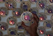 A family member of the missing Malaysia Airlines flight MH370, steward Mohd Hazrin Mohamed Hasnan, holds a candle bearing his name during a remembrance event marking the 10th anniversary of its disappearance, in Subang Jaya, Malaysia March 3, 2024. 