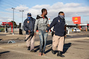 Police detain a man suspected of looting at a shopping centre in Vosloorus, Johannesburg, South Africa.