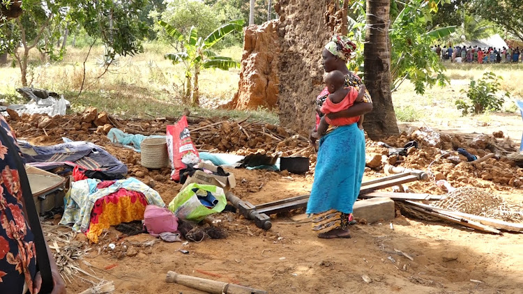 A mother with her child look at their demolished home at Msabaha in Malindi