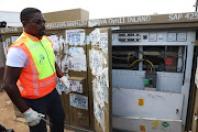 City power officials investigating a meter at an Engen garage in Alex, Johannesburg.

