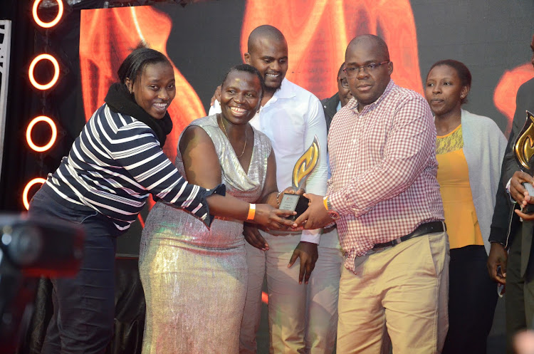 ICPAK council member CPA Susan Oyatsi presents an award to NIC Bank PLC, who were the overall winner for Listed Category