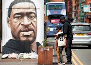 A mural of George Floyd in Manchester, England. The white officer stopped kneeling on the suspect after he cried out 