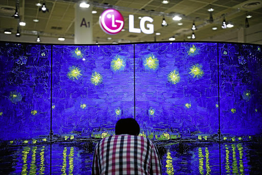 A man examines a double-faced OLED TV, made by LG, during the Korea Electronics Show 2016 in Seoul. At this year's CES show in Las Vegas, rival Samsung revealed a new technology called QLED.