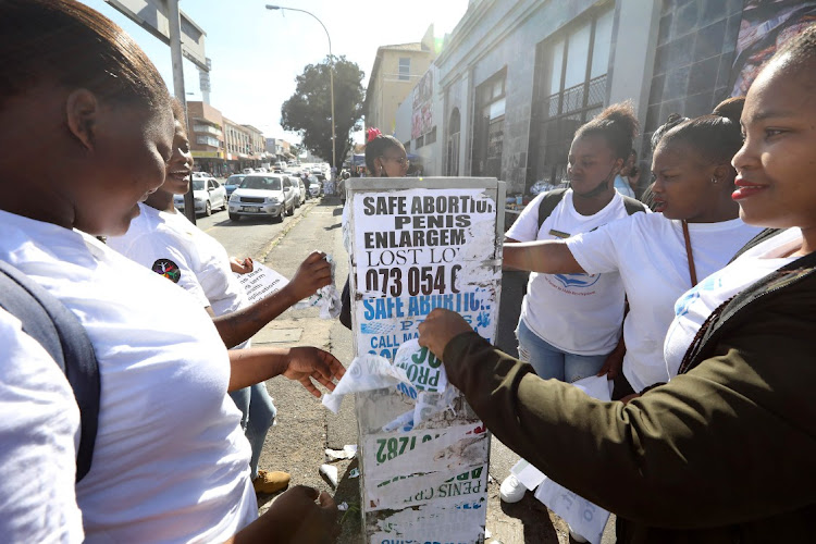 Employees of the Buffalo City metro, the department of health and volunteers remove illegal abortion posters in East London. Picture: ALAN EASON